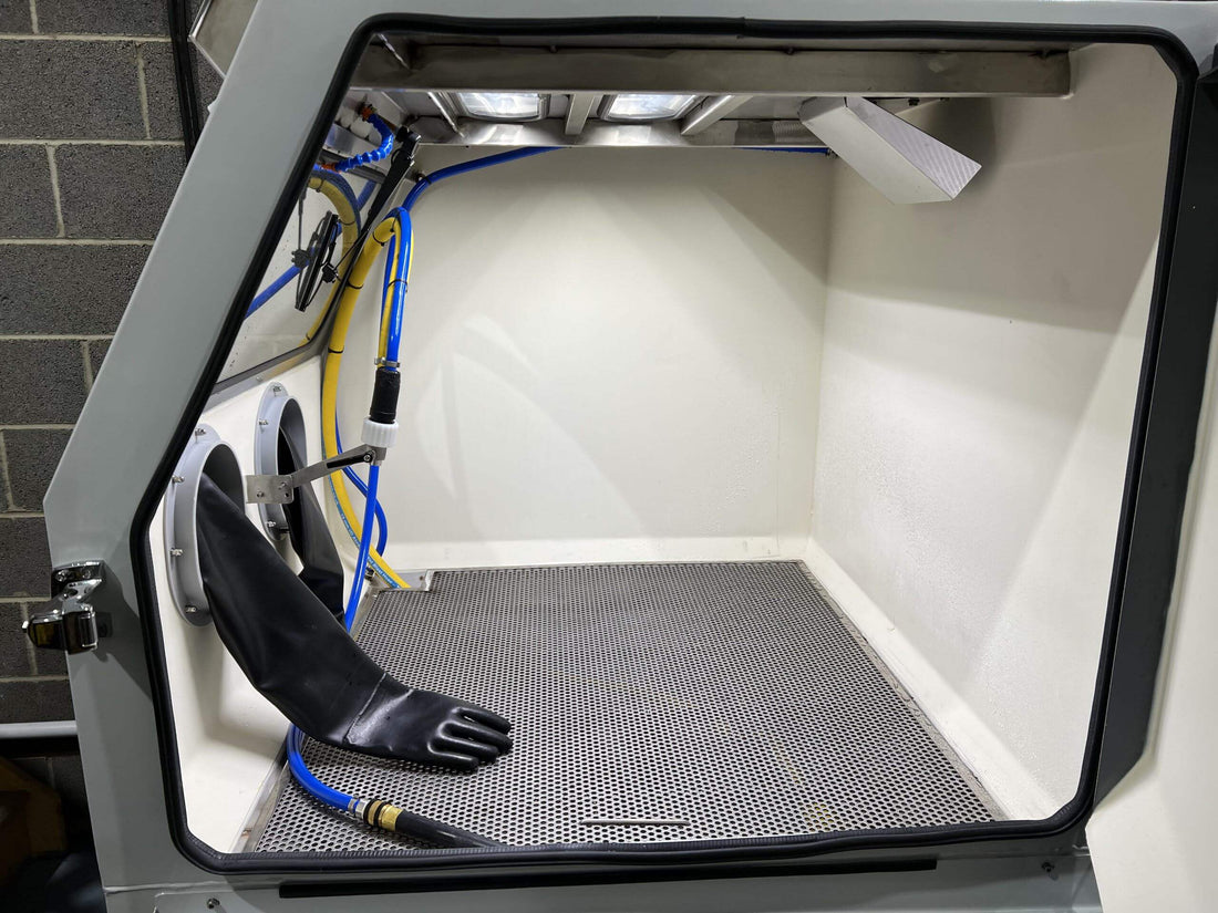Blast Cleaning: Benefits, and Best Practices - interior of a blast cleaning cabinet with gloves and equipment