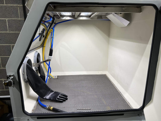 Blast Cleaning: Benefits, and Best Practices - interior of a blast cleaning cabinet with gloves and equipment
